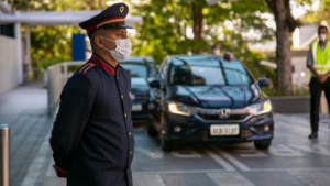 Homem com uniforme de Capitão Porteiro parado na chegada do estacionamento do Hospital Albert Einstein